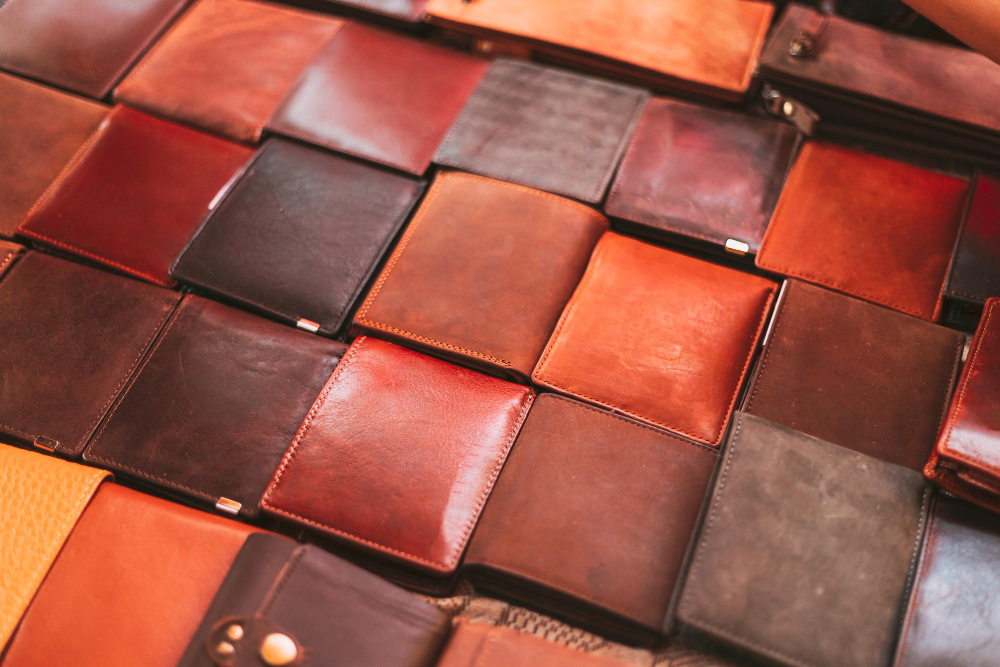 Portefeuilles en cuir disposés en mosaïque, illustrant la gestion de production et l’optimisation des performances en maroquinerie