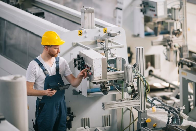 Technicien configurant une machine spéciale dans un atelier de production à l'affaire