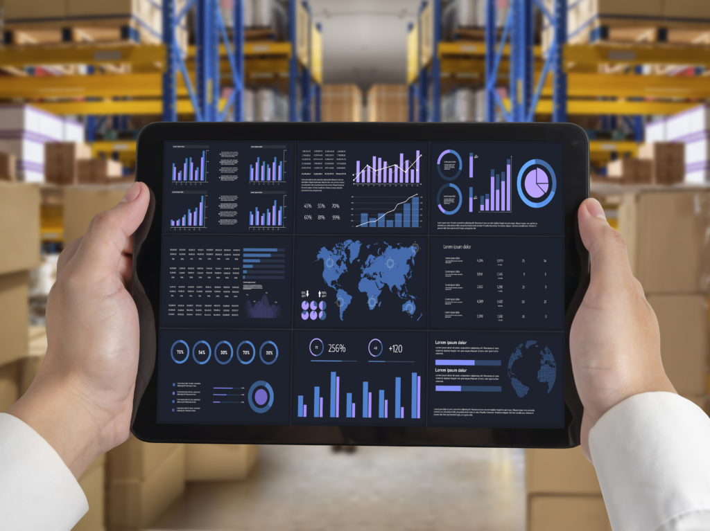 Tablette affichant un tableau de bord ERP dans un entrepôt, illustrant la gestion de production des modèles MTS, ATO, MTO et ETO