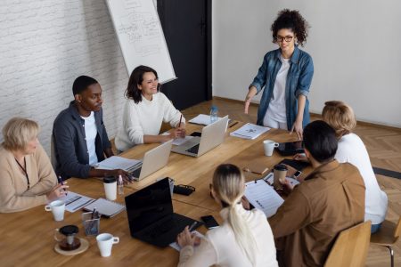 Réunion d’équipe autour d’une table illustrant la gestion commerciale optimisé par l'ERP d'Open-Prod.